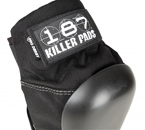 Close-up of the 187 Killer Pro Derby Knee Protection Pads in black, featuring a hard protective cap ideal for action sports. The design includes the "187" logo and a "Pro Derby" label on the fabric above the cap. These pads also utilize V-22™ Dual Density Foam for enhanced comfort and security.