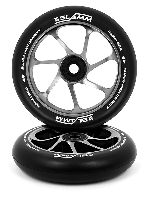 Displayed are two Slamm Team 110mm Stunt Scooter Wheels in black and silver, boasting a five-spoke design. They feature high-rebound PU construction and an aluminum core, with the brand "SLAMM" and the phrase "SUPER HIGH DENSITY" visible on their edges. The wheel in the back is upright, while the one in front is positioned flat.