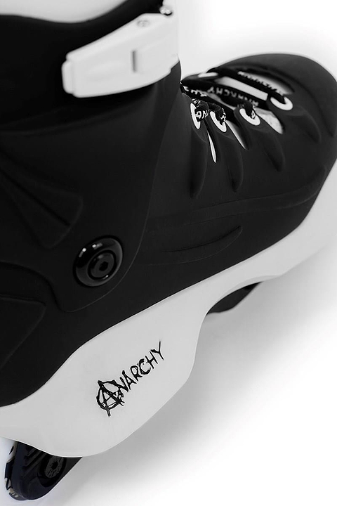 Close-up of Anarchy Revolution II Aggressive Inline Skates in black, featuring a graffiti-style "Anarchy" logo. Designed for tricks and grinds with a sleek boot and white buckle, these skates are perfect for beginner and intermediate skaters.