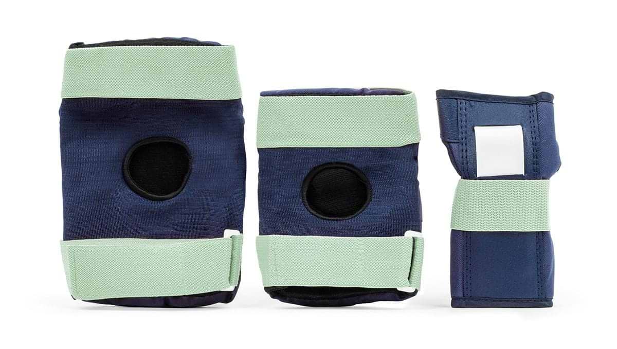 The REKD Heavy Duty Triple Skate Protection Pad Set in Blue / Mint includes two knee pads, one wrist guard, and a pair of elbow pads. The set showcases dark blue fabric with light green adjustable straps and black cushioning, all arranged neatly against a white background.