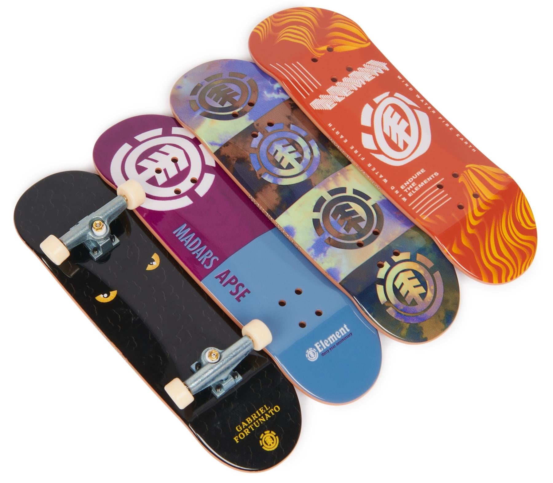 Four Tech Deck M01 Deluxe 4 Pack Fingerboards - Element boards are arranged overlapping, displaying vibrant designs and logos. One includes wheels, while the others are decks—perfect display inspiration for your own Tech Deck collection.