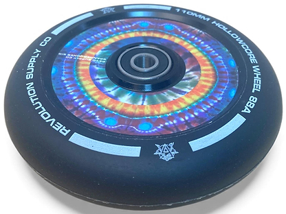 A close-up of the Revolution Hollowcore 110mm Stunt Scooter Wheel - Spanner Jones Signature by Revolution, featuring a colorful tie-dye core, visible ABEC 9 bearing, and white text and symbols on the black wheel's edge.