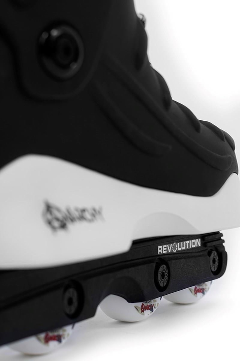 Close-up of Anarchy Revolution II Aggressive Inline Skates - Black, featuring a white sole and the "Anarchy" brand on the frame. These durable skates are designed for performance with a subtle logo near the heel and four wheels underneath, perfect for aggressive inline skating.