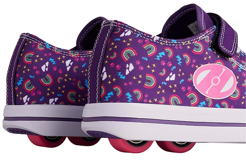 A pair of Heelys Snazzy X2 Girls Shoes by Heelys in purple with a rainbow print, pink wheels, two wheels per shoe, and a pink circular logo—perfect for extra fun.