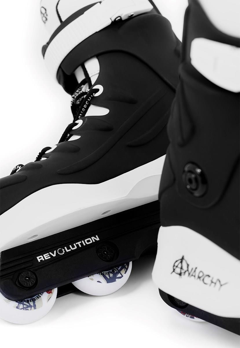 Close-up of two black Anarchy Revolution II aggressive inline skates, with bold "REVOLUTION" and "ANARCHY" branding. Ideal for beginner and intermediate skaters, the wheels have a subtle design with hints of color, enhancing tricks and grinds.