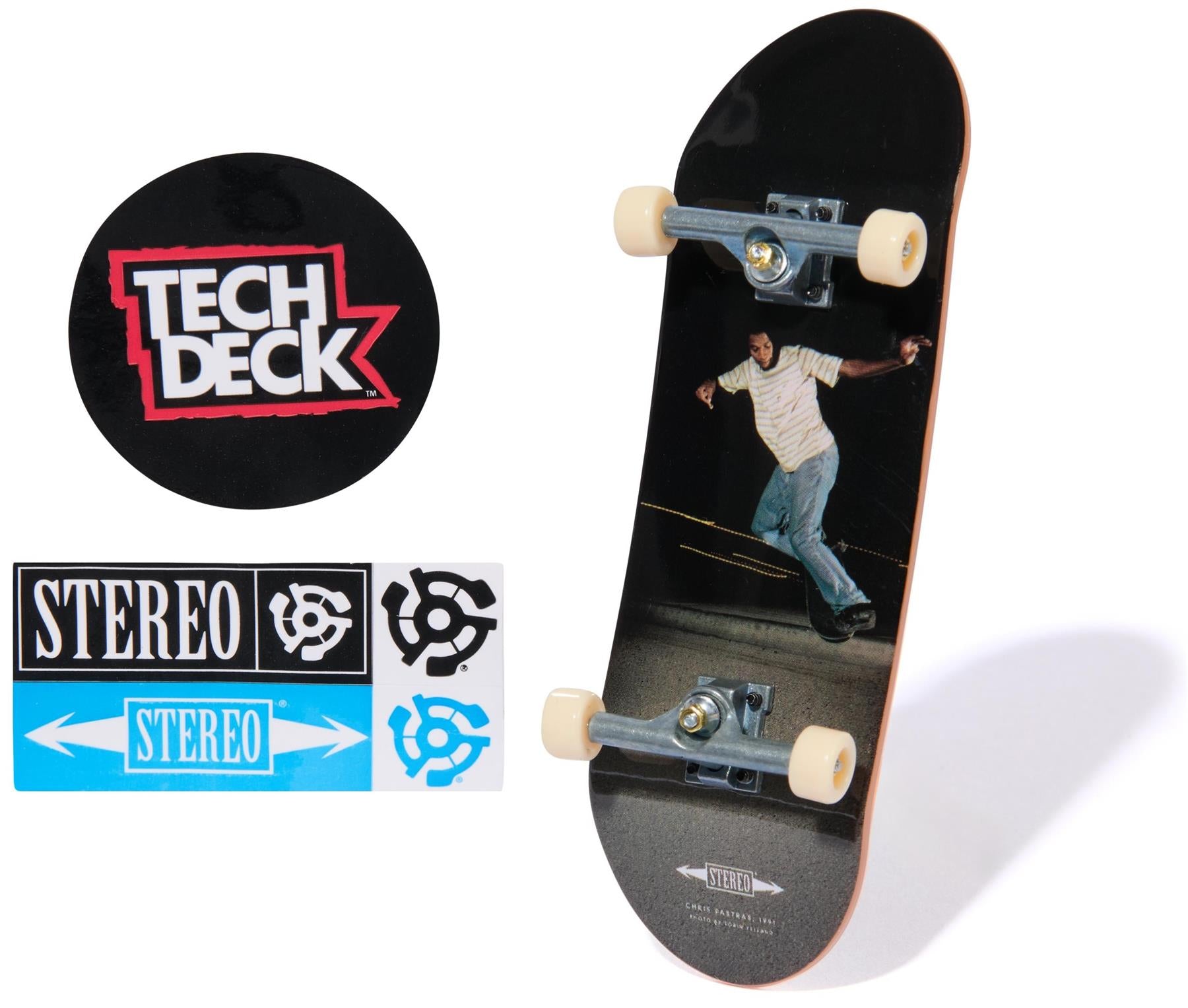 The Tech Deck 96mm M57 Fingerboard - Stereo features a skateboarder photo on the deck, plus a round Tech Deck logo sticker and three black, white, and blue Stereo brand stickers.