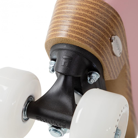 Close-up of the Rookie Classic 78 Quad Roller Skates - Pink by Rookie, featuring white wheels, a black metal truck, a brown wood-textured heel with a metal screw, and a pink body.