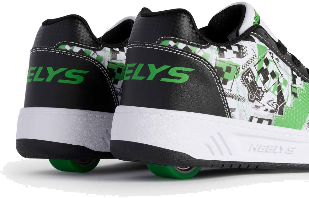 A close-up of the Heelys x Minecraft Kama Boys Shoes by Heelys in white, black, and green, featuring a single green wheel in each heel and bold green “HELYS” lettering on the back.