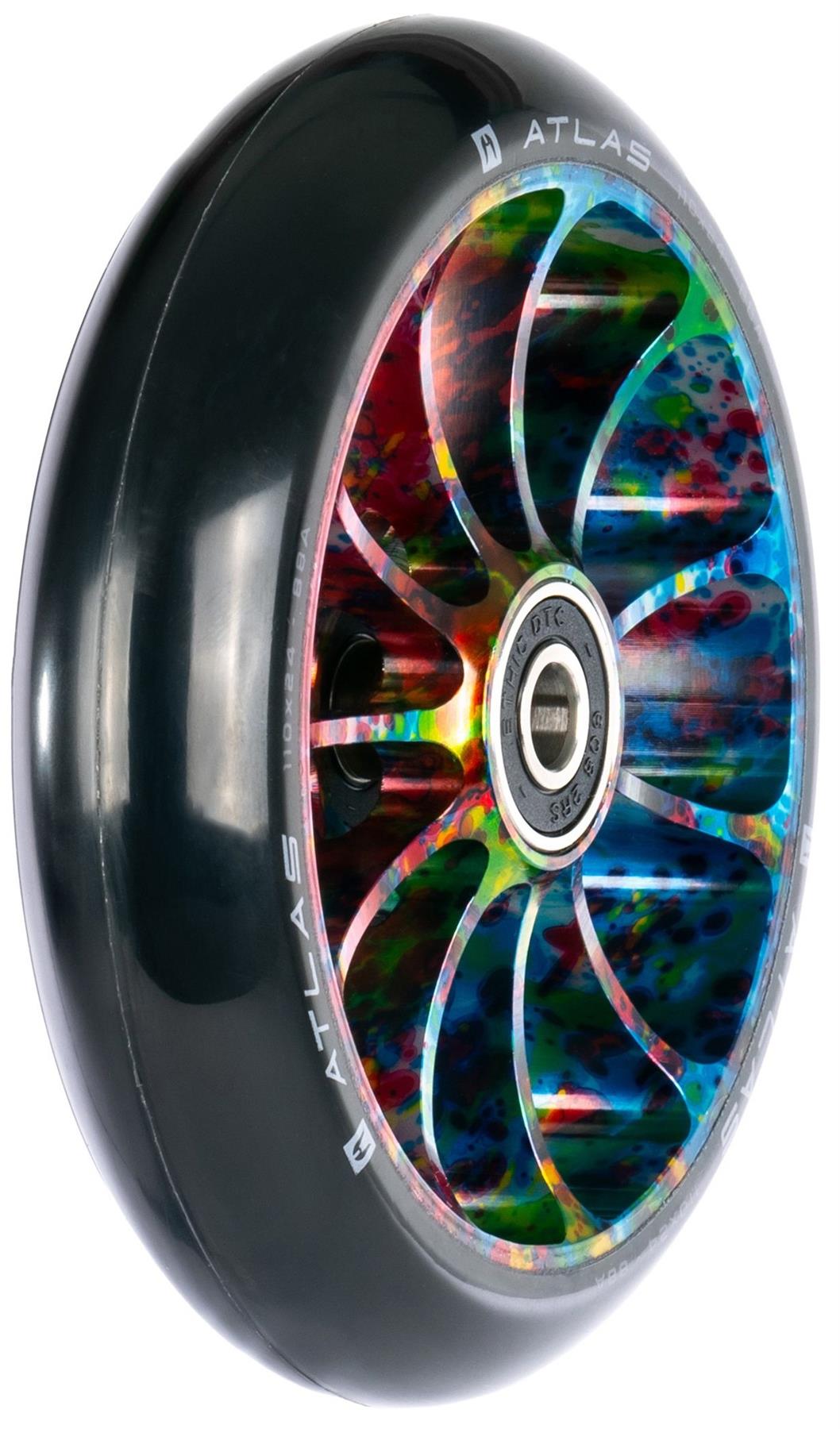A close-up of the Ethic DTC Atlas 110mm Stunt Scooter Wheel - Nebula by Ethic, featuring a black rubber outer layer, a multicolored metal core with intricate cut-out spokes, and a visible ball bearing in the center.