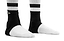 Two feet wearing REKD Energy Slim Footies Ankle Protection Pads in black, along with white socks featuring black stripes, are shown standing on a white background for ultimate ankle protection.