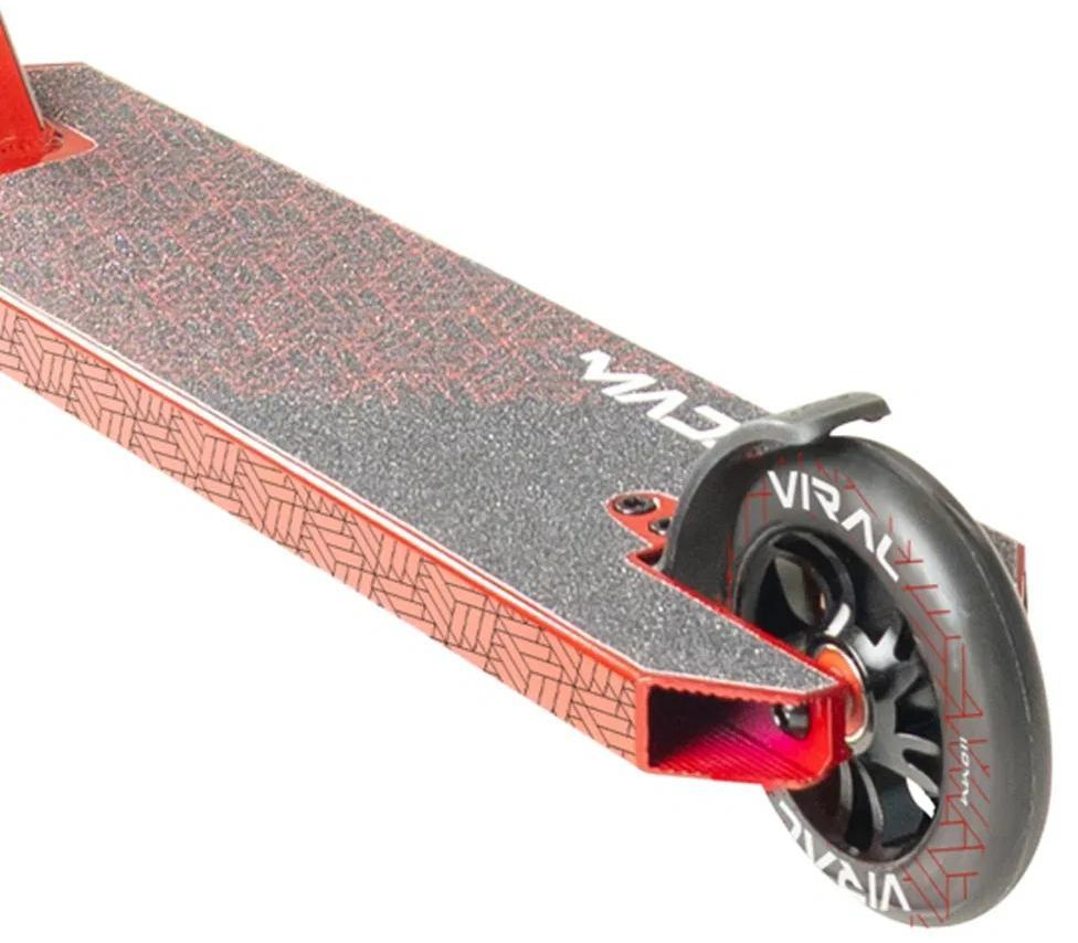 Close-up of the Madd Gear Viral Purge Complete Stunt Scooter - Cherry, showing its deck with black geometric grip and a wheel edged with "VIRAL"—ideal for skatepark tricks.