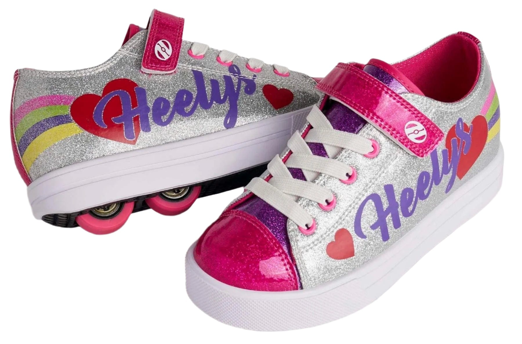 Two Heelys Snazzy X2 Girls Shoes by Heelys in silver with rainbow stripes and pink hearts. Features glittery uppers, pink wheels, "Heelys" in purple, and a versatile design: one shoe shows 2 wheels per shoe while the other lays flat.