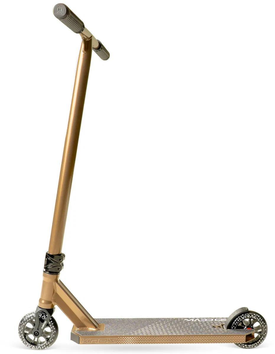 The Madd Gear Viral KAOS Complete Stunt Scooter in Ash, featuring black grips, a textured silver foot deck, and two black and silver wheels, is shown from the side against a white background.
