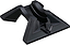 A black Blunt Envy Scooter Stand V2 showcases a futuristic design with sharp edges and geometric shapes. It features a sleek, glossy finish on the base and includes a central groove to accommodate 30mm wide wheels, with a web link printed along its edge.