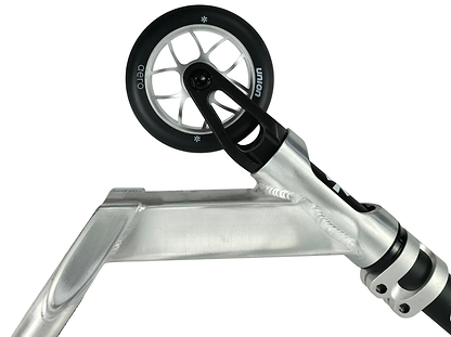 Close-up of the Union Aero Complete Stunt Scooter by Union in Black / Raw, highlighting the front wheel, fork, metal deck, clamp, and black wheel with white spokes against a white background.