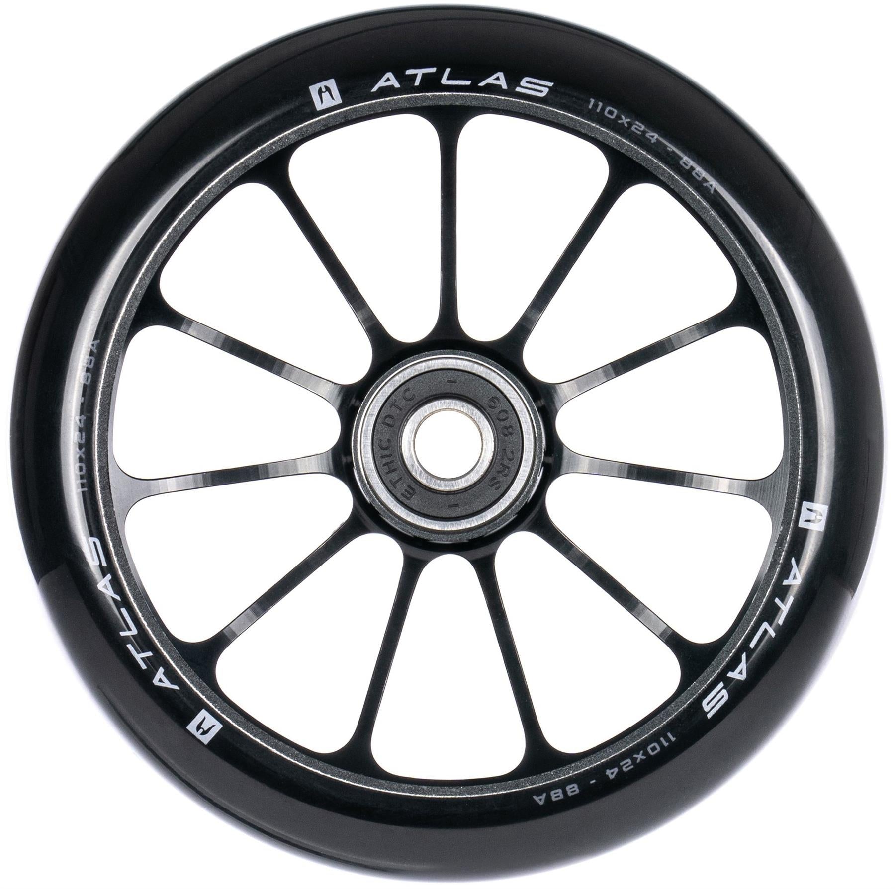 A close-up of the Ethic DTC Atlas 110mm Stunt Scooter Wheel in black, showing its twelve-spoke design, central bearing, and white specs on the rim. This lightweight performance wheel is made by Ethic.