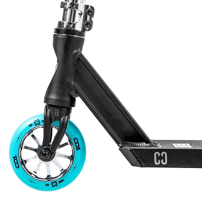 Close-up of the front wheel and part of the deck of a chrome and teal CORE CD1 Complete Stunt Scooter by CORE, featuring a bright blue wheel with white spokes and "CO" lettering on the metallic-finish frame.