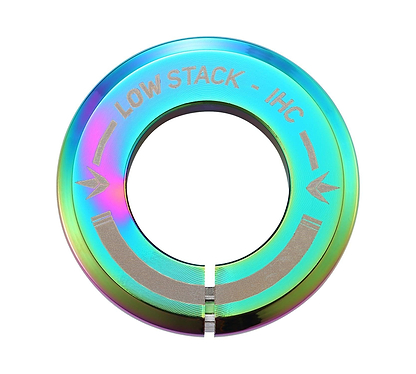 The Blunt Envy Low Stack IHC Integrated Stunt Scooter Headset in Oil Slick Neochrome features a circular, metallic design with an iridescent finish and the text "LOW STACK - IHC" accompanied by two arrow-like symbols. It includes a bottom slit and boasts a shiny, reflective surface with sealed bearings perfect for use with an IHC compression system.