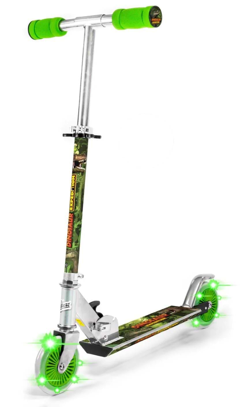 The Ozbozz Dinosaur Expedition Light Up Foldable Kids Kick Scooter in silver and green features green foam handlebars, green light-up wheels, a dinosaur-themed deck, and "Dinosaur Scooter" printed on the stem.