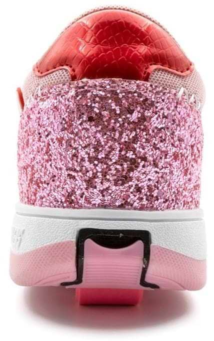 The image shows the back view of Breezy Rollers Star Shoes - Pink, featuring sparkling pink glitter, a textured red heel, a white sole, and the brand's patented wheel system embedded in the heel for rolling fun.