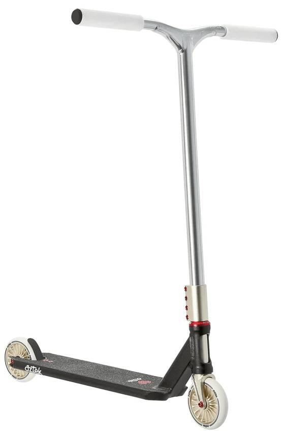 The Aztek Corsa Complete Stunt Scooter in black features silver and black styling, white handlebar grips, small cream wheels, a lightweight design, textured foot deck, and bold red accents near the front wheel. Shown against a white background.