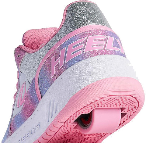 Close-up of Heelys Rezerve Low Girls Shoes in Lt Pink/White/Rainbow, featuring a glittery finish, rear wheel in the sole, pink outsole, and "HEELY" logo—perfect for anyone seeking beginner-friendly Heelys style.