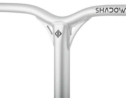 Close-up of a metallic handlebar with a smooth design, marked "SHADOW" for the Drone Shadow 2 series. A geometric logo decorates the center of the textured aluminium IHC surface with visible welds, crafted for stunt scooter bars by Drone.