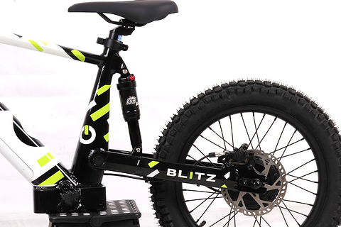 Close-up of the Duo 18" Blitz Kids Electric Balance Bike in White/Black, highlighting the thick rear tire, disc brake, suspension, and part of the frame against a white background.
