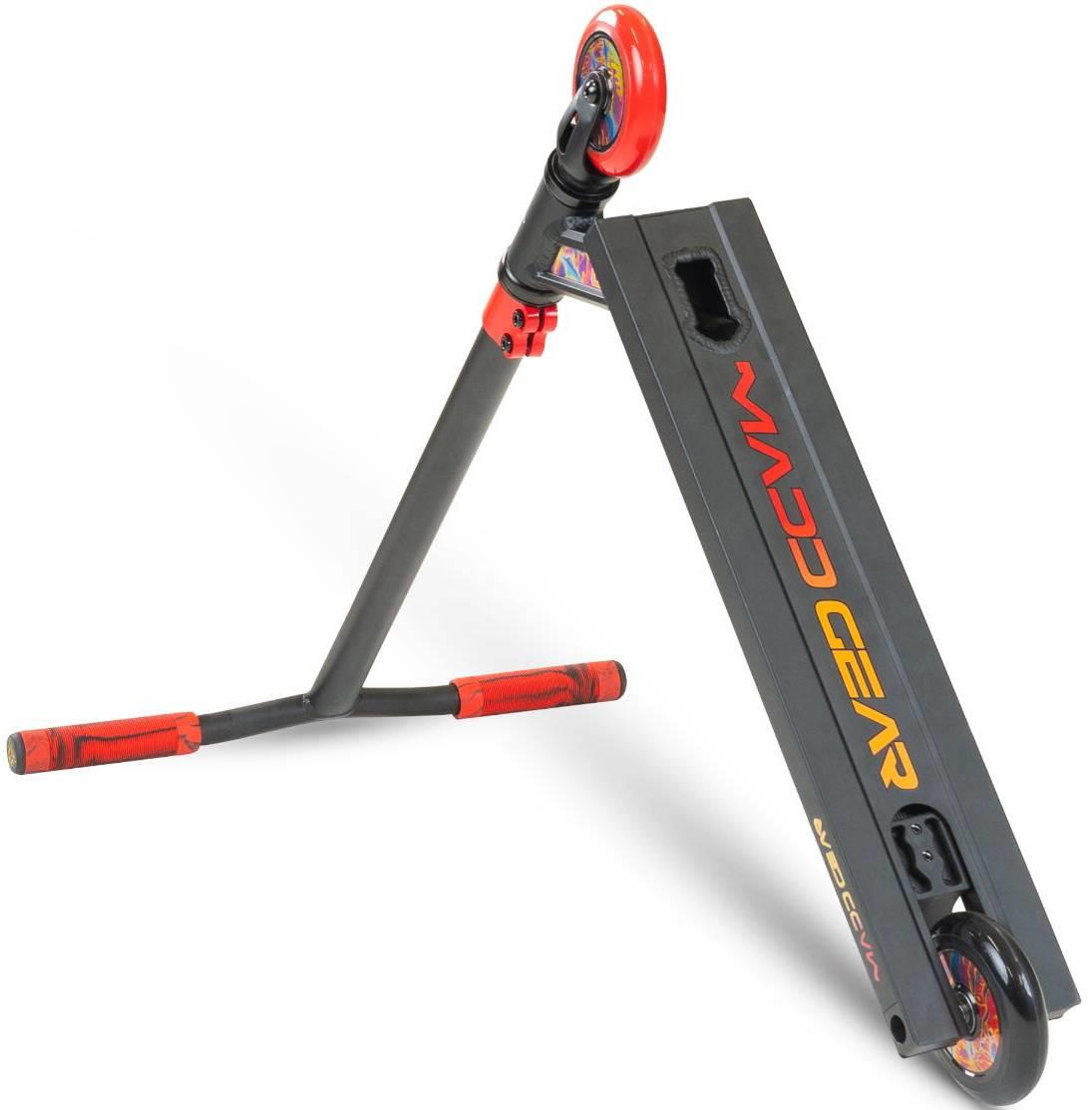 A Madd Gear MG 2 Obsidian Complete Stunt Scooter - Frenzy, in black and red, is pictured with its deck angled up and one handlebar on the ground. The deck displays "MADD GEAR" in bold lettering.