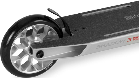 Close-up of a silver Drone Shadow 3 Evo Complete Stunt Scooter deck and rear wheel, highlighting the brake and grip tape.