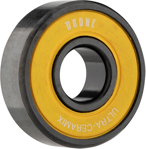 A circular Drone Ultra-Ceramix scooter bearing with a black outer ring and a yellow inner seal printed with the text “DRONE” and “ULTRA-CERAMIX.”