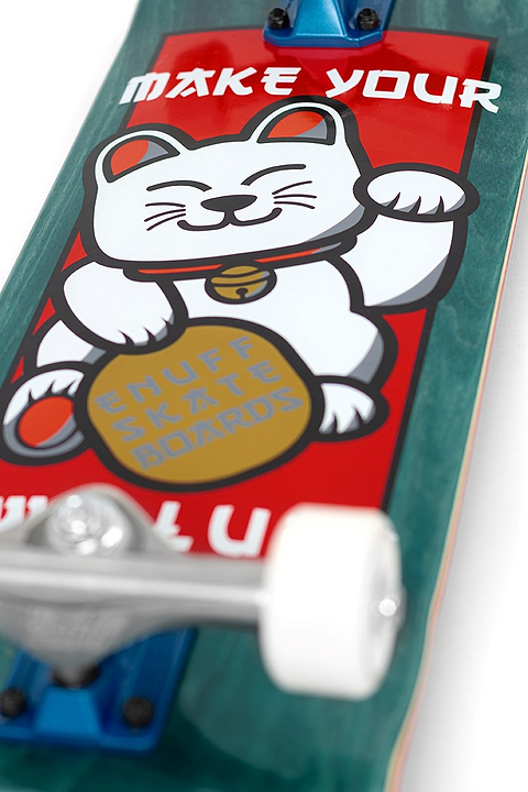 Close-up of the Enuff Lucky Cat Green Complete Skateboard - 8″ x 32″, a beginner board featuring a lucky cat graphic holding a gold coin reading “SNUFF SKATE BOARDS.” The top displays “MAKE YOUR,” with wheels and trucks visible at the bottom, making it perfect for street and park skating.