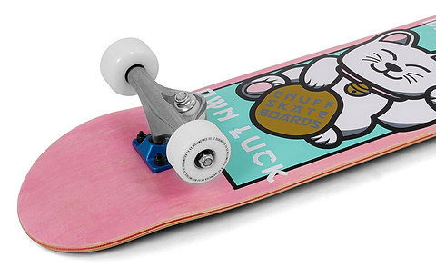 The Enuff Lucky Cat Mini Pink Complete Skateboard - 7.25″ x 29.5″ by Enuff features white wheels and a cheerful lucky cat graphic holding a coin on the deck, which is decorated with the phrases “OWN LUCK” and “ENUFF SKATE BOARDS.” Ideal as a beginner or kids skateboard, it’s perfect for young riders looking to get started.