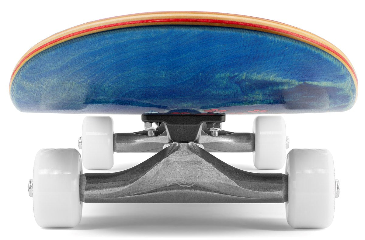 Close-up, low-angle view of the Enuff Yokai Kitsune Complete Skateboard (8.25" x 32.1"), highlighting the Enuff trucks, white wheels, and blue 7-ply maple deck with a red edge inspired by Japanese folklore.