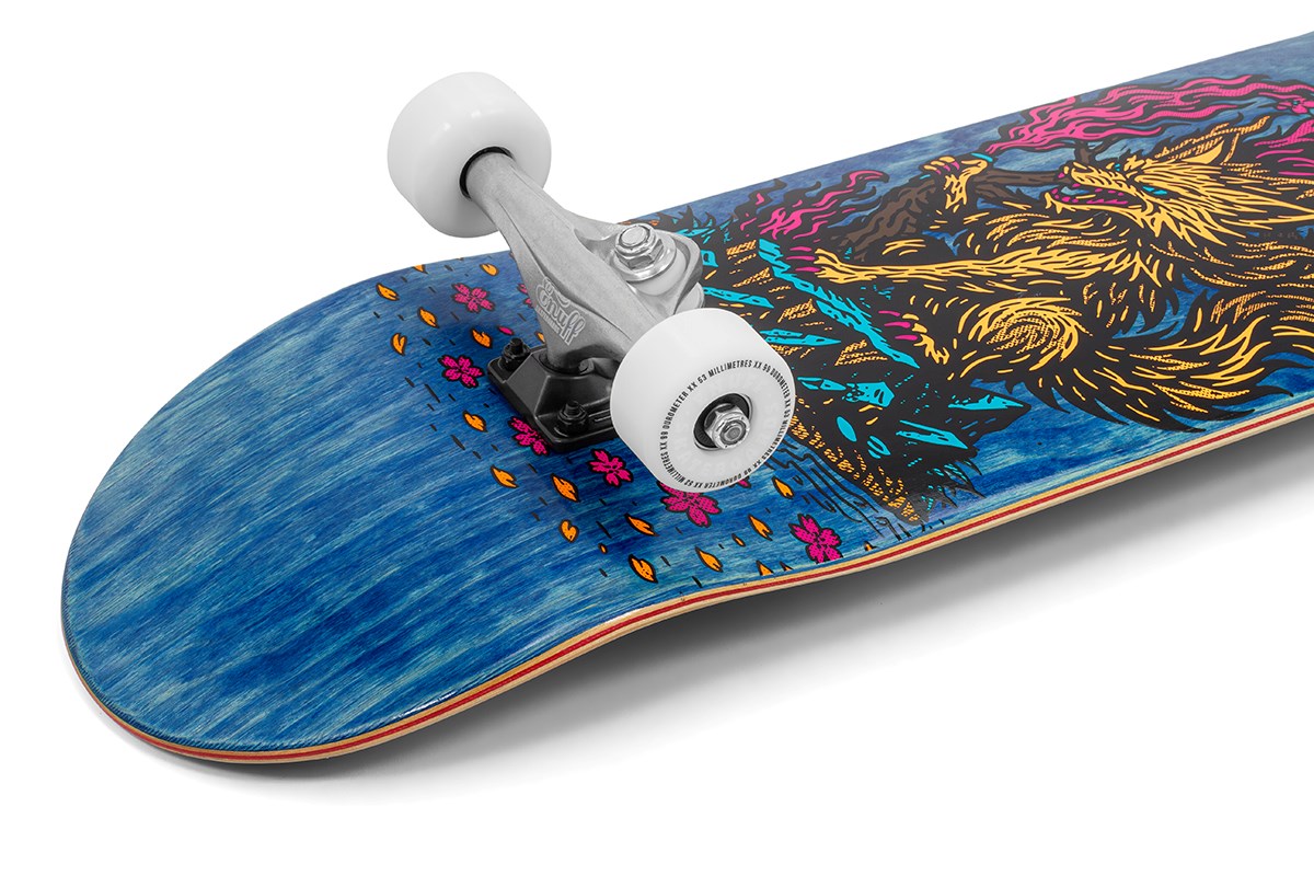 A close-up of the Enuff Yokai Kitsune Complete Skateboard (8.25" x 32.1") by Enuff, featuring white wheels, silver trucks, and a blue deck with a vivid yellow kitsune wolf graphic inspired by Japanese folklore, flowers, and flame motifs.