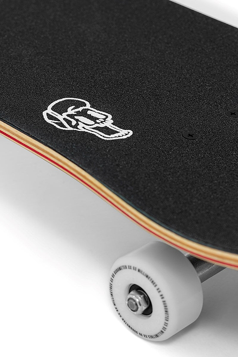 A close-up of the Enuff Throwback Black Complete Skateboard (8.5" x 32.1") shows black grip tape with a white skull graphic near the nose and a white wheel underneath.