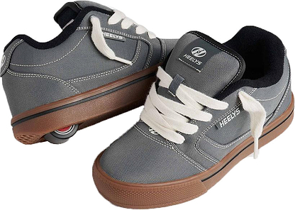 A pair of Heelys Pro 25 Boys Shoes in grey, antique white, and black by Heelys; one shoe features a visible wheel in the heel.