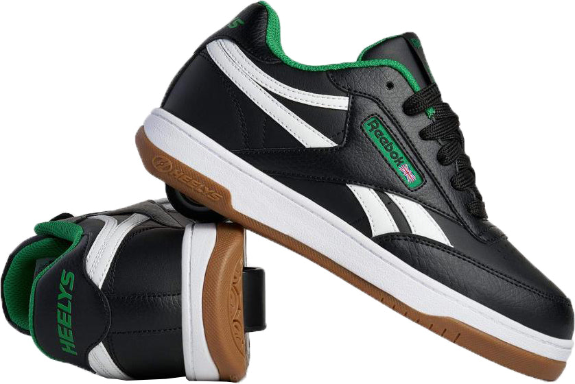 Two Heelys x Reebok Classic Boys Shoes - Black / White / Gum are shown: one upright, one on its side highlighting the brown gum sole, both featuring classic retro style and a wheel in the heel.
