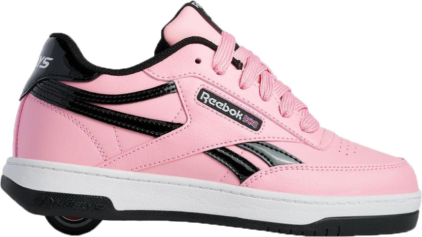 The Heelys x Reebok Club C Girls Shoes - Candy Pink / Black / White features pink with black accents, white sole, pink laces, the logo, and a small Union Jack flag; part of the Heelys collection.