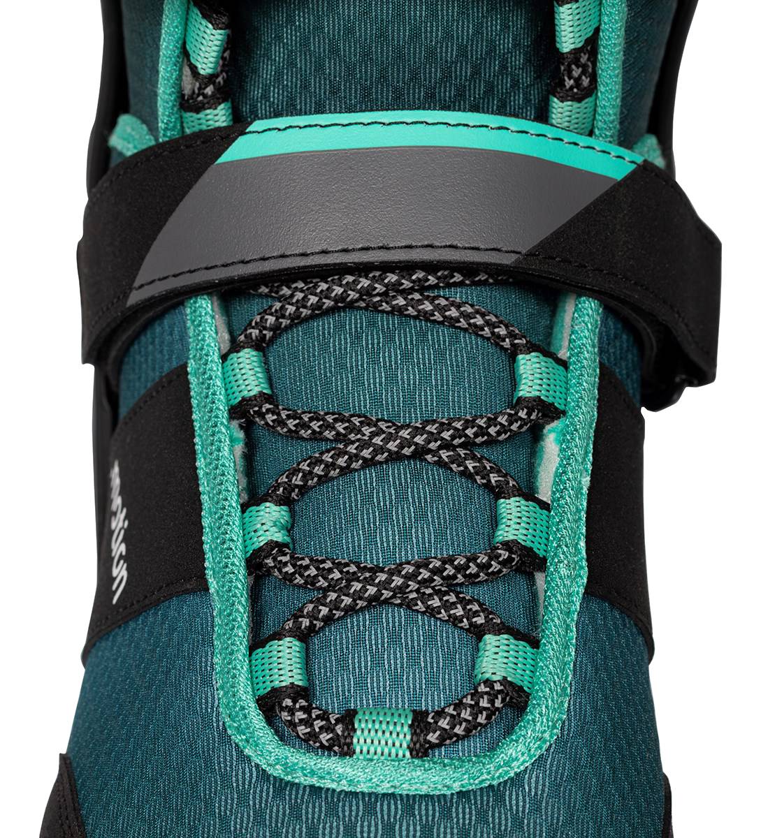 Close-up of a .motion Dreamstate Inline Skates - Teal, featuring black laces and a wide hook-and-loop strap across the ankle.
