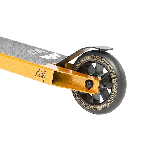 Close-up of the rear wheel and deck on the Nitro Circus Ryan Williams Junior Replica 2025 Complete Stunt Scooter in gold/black, showing black grip tape with white logos, a black brake, and a detailed patterned wheel against a white background.