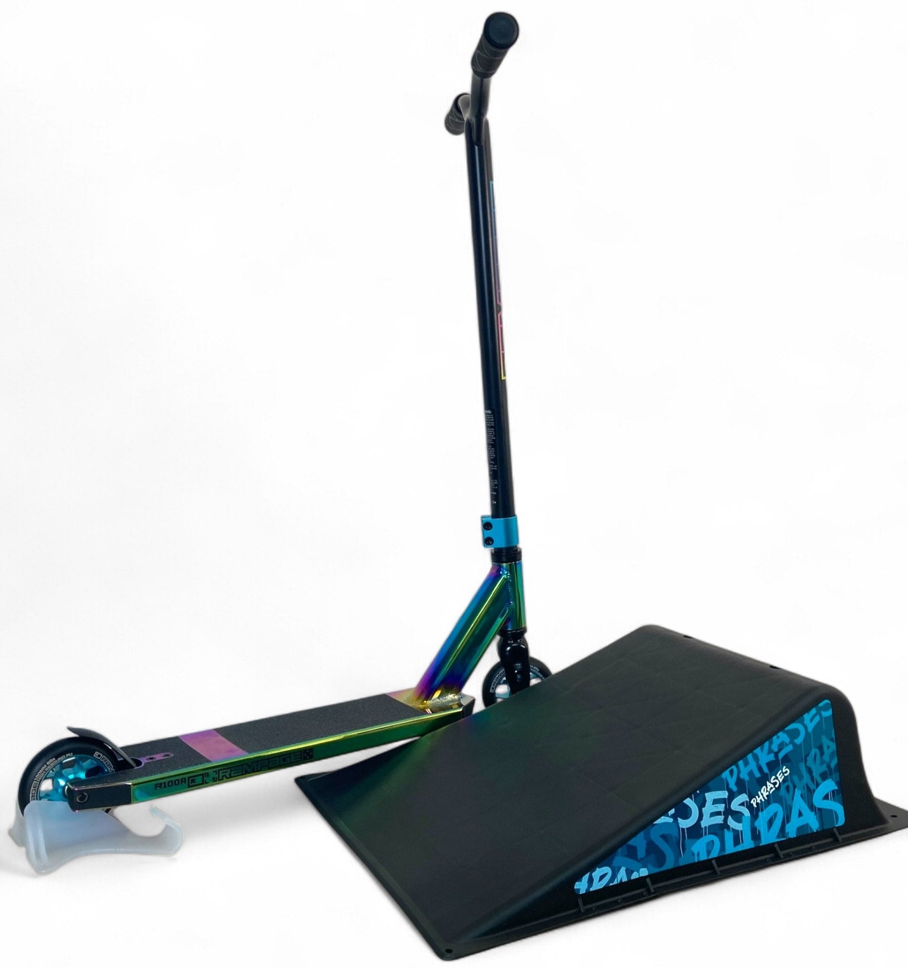 A colorful stunt scooter balances its front wheel on the Phrases One Way Kicker Skate Ramp by Phrases, featuring blue text on the side, set against a plain white background.
