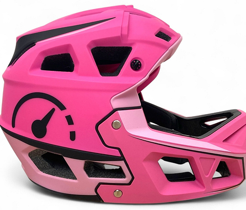 The Revvi Kids Full Face MTB Helmet in bright pink features black and white accents, a speedometer graphic on the side, and angular vents—perfect for young riders seeking style and protection.