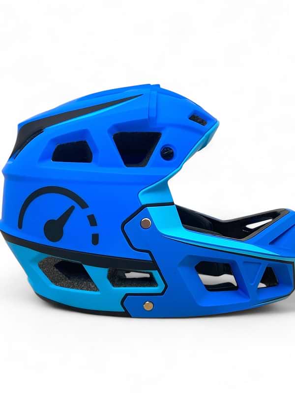 The Revvi Kids Full Face MTB Helmet - Blue by Revvi is a lightweight kids' helmet with angular vents and a black speedometer graphic, shown on a plain white background.