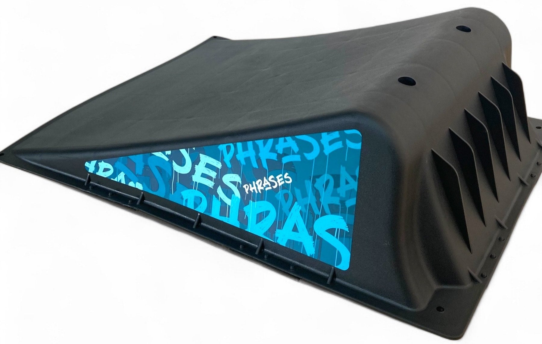 The Phrases One Way Kicker Skate Ramp by Phrases is a black plastic ramp with a sloped surface, blue graphic accents, and ventilation holes—ideal for beginner skateboarders. Shown on a white background.