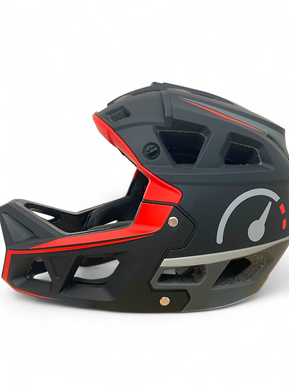 The Revvi Kids Full Face MTB Helmet - Black by Revvi features a black and red design with speedometer graphic, angular vents, matte finish, and adjustable fit—ideal for young riders wanting a lightweight kids helmet.