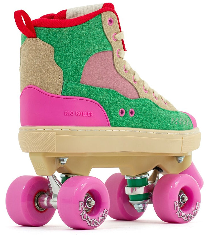 The Rio Roller Beats Quad Roller Skates - Pink / Green feature a retro vegan high-top boot in green, pink, and beige with pink wheels and a cream sole. "Rio Roller" branding is visible on the side. Shown from the back left angle.