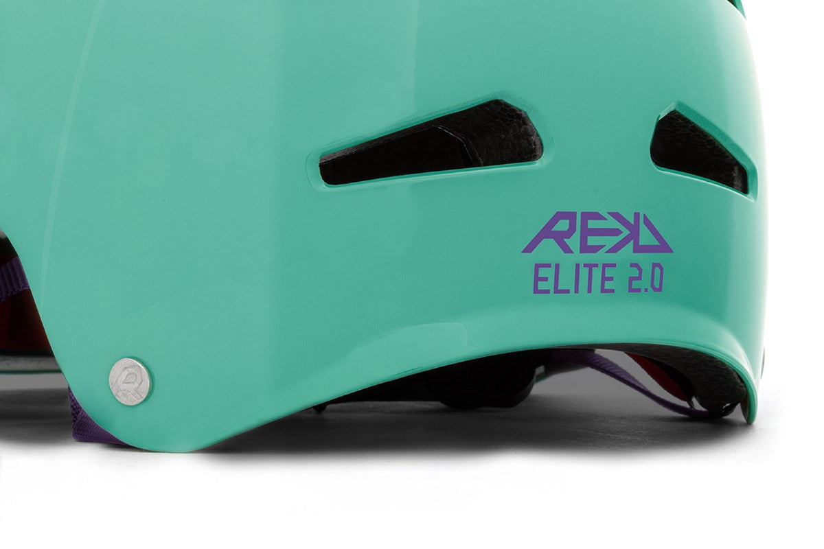 Close-up of the REKD Elite 2.0 Skate / Scooter Helmet in gloss teal, featuring black ventilation slits, purple "REKD ELITE 2.0" text on the side, and a silver rivet—designed for action sports.