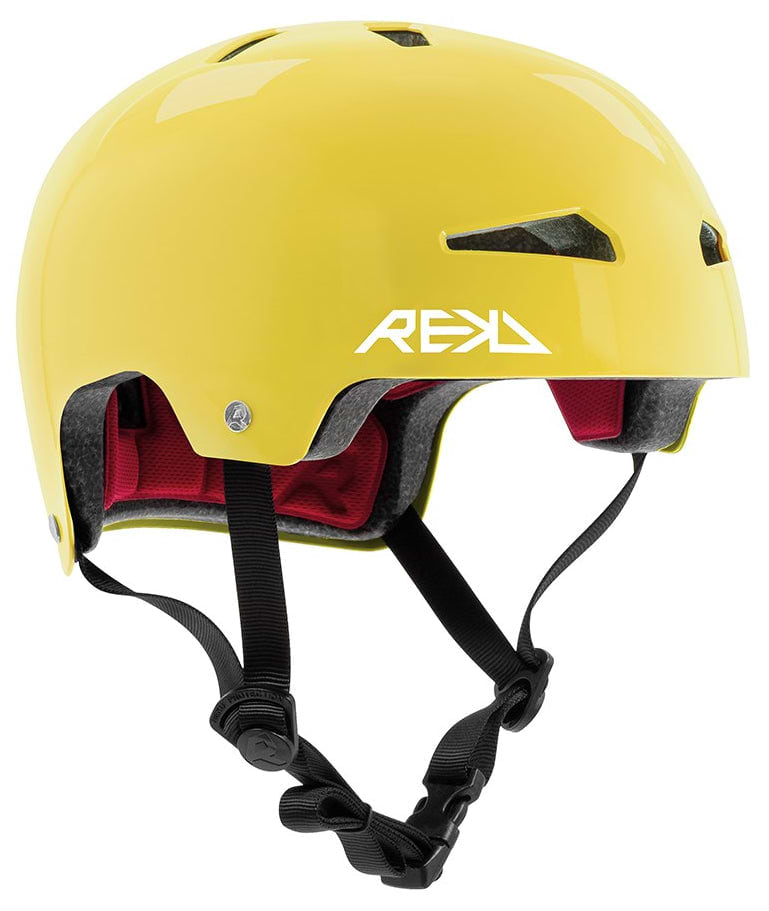 The REKD Elite 2.0 Skate / Scooter Helmet in gloss yellow features a lightweight design, black adjustable chin strap, red interior padding, ventilation holes, and a white REKD logo on the side.