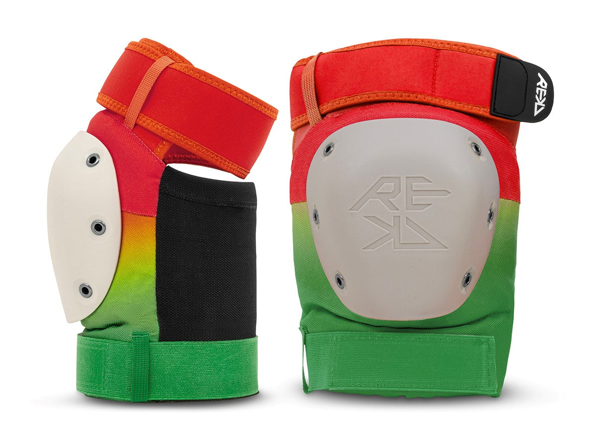 A pair of REKD Shield Triple Skate Protection knee pads in Fade Orange / Green, featuring a colorful design with red, yellow, black, and green sections, white plastic caps with the embossed “REKD” logo on one cap, and adjustable straps for secure fit. Designed by REKD for action sport protection.